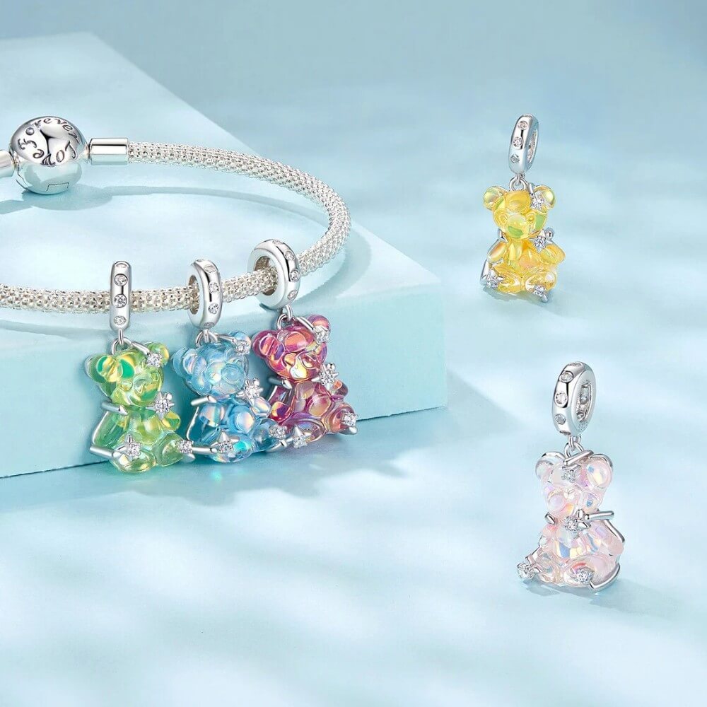 Sterling silver teddy bear charm with pink opalescent glass and crystal accents.