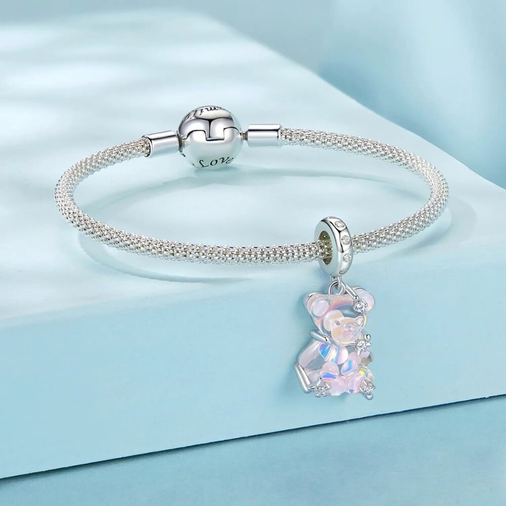 Sterling silver teddy bear charm with pink opalescent glass and crystal accents.