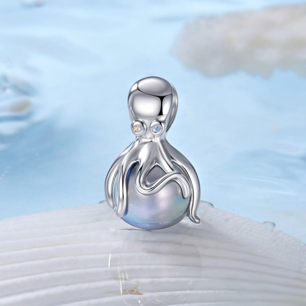 Sterling silver octopus charm holding iridescent pearl sphere.