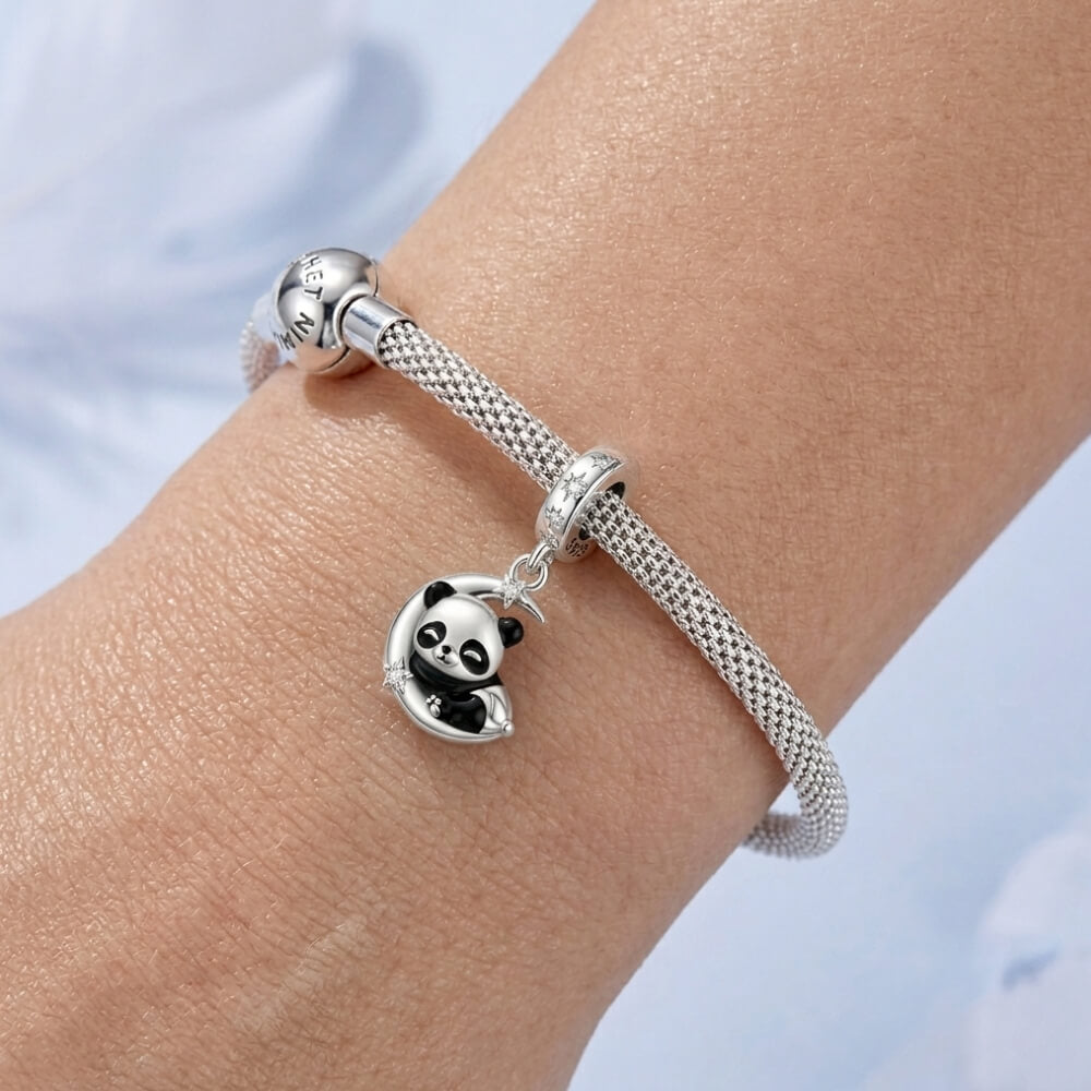 Sterling silver panda charm resting on crescent moon with star details.