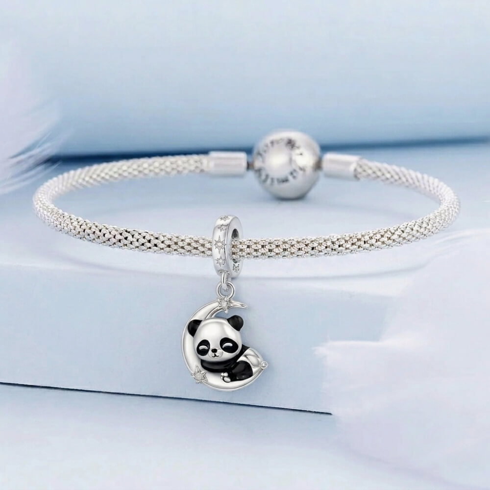 Sterling silver panda charm resting on crescent moon with star details.