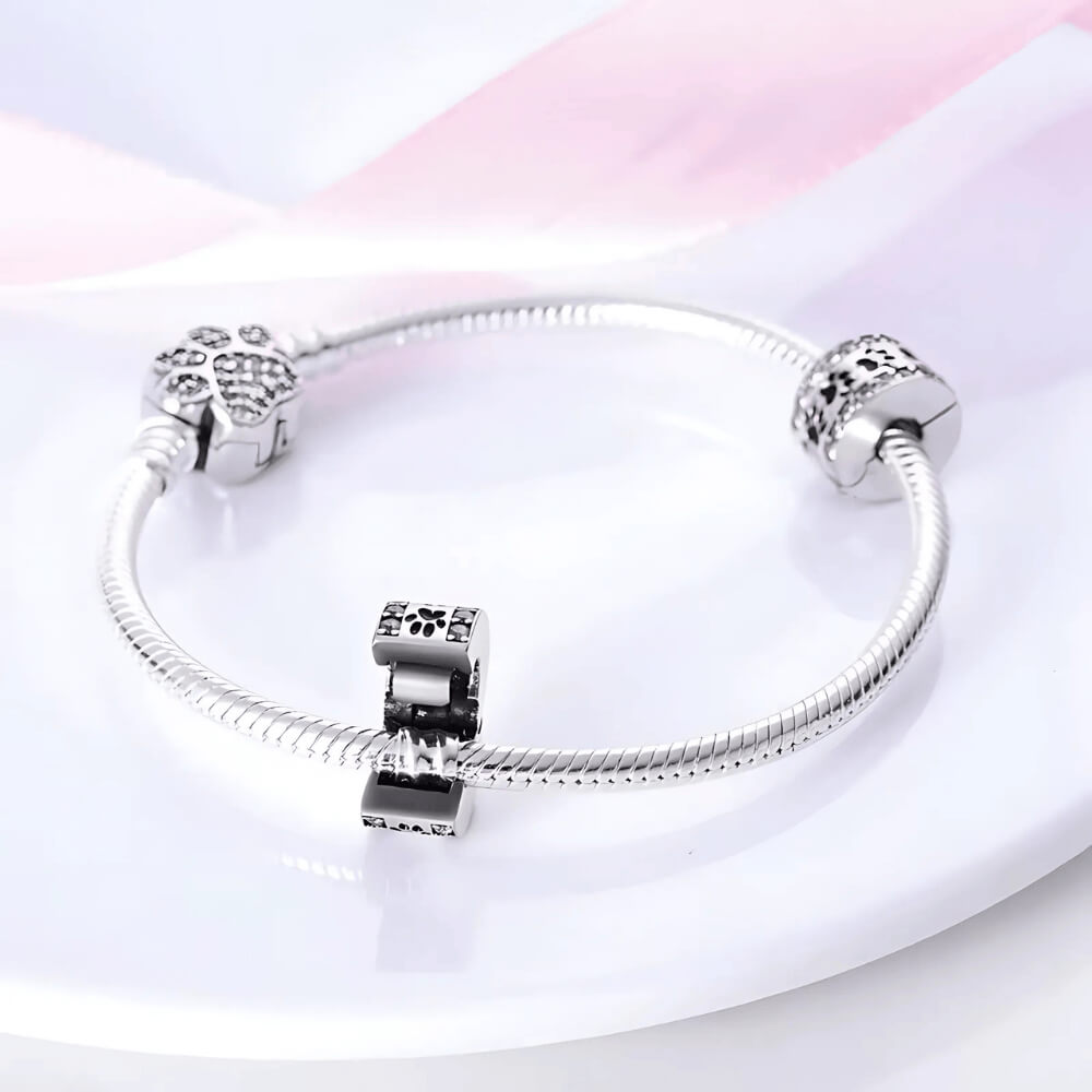Sterling silver clip charm with black enamel paw prints and clear zircon borders 