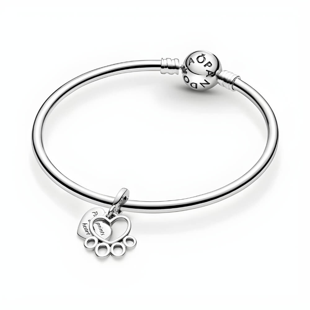 Sterling silver charm with heart outline paw print and engraved ‘Pawprints on my heart’ tag
