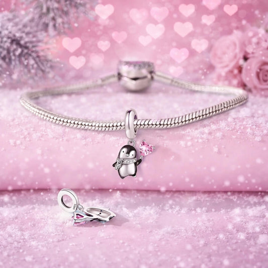 Sterling silver penguin charm holding pink heart crystal.