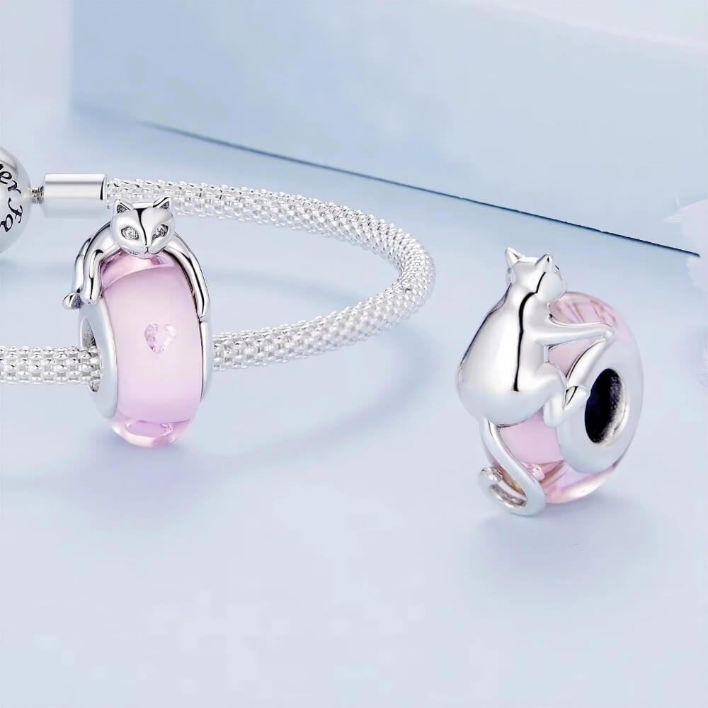 Sterling silver cat charm with pink crystal body and heart detail.