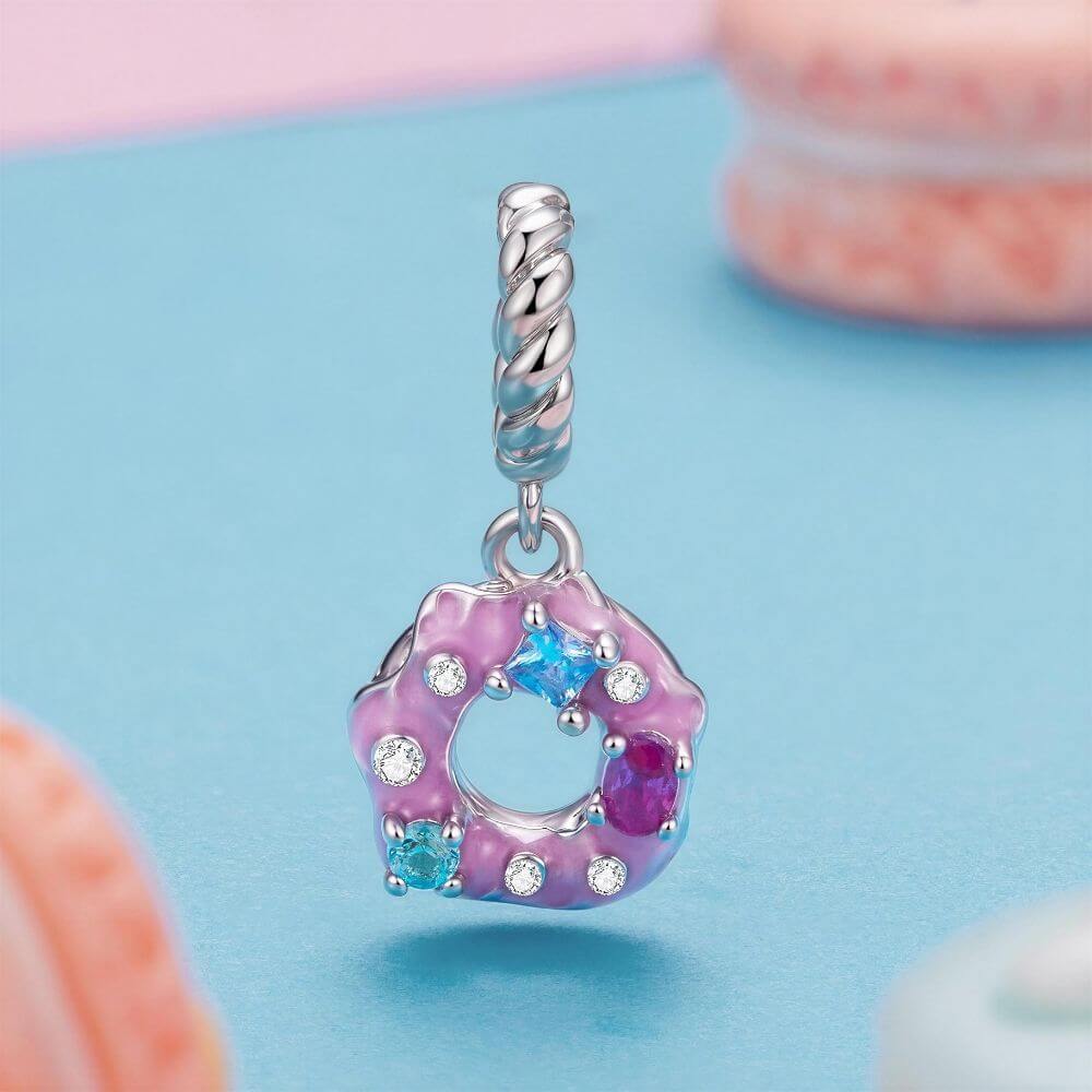 Sterling silver donut charm with pink frosting, colorful crystal sprinkles, and a twisted silver bail.