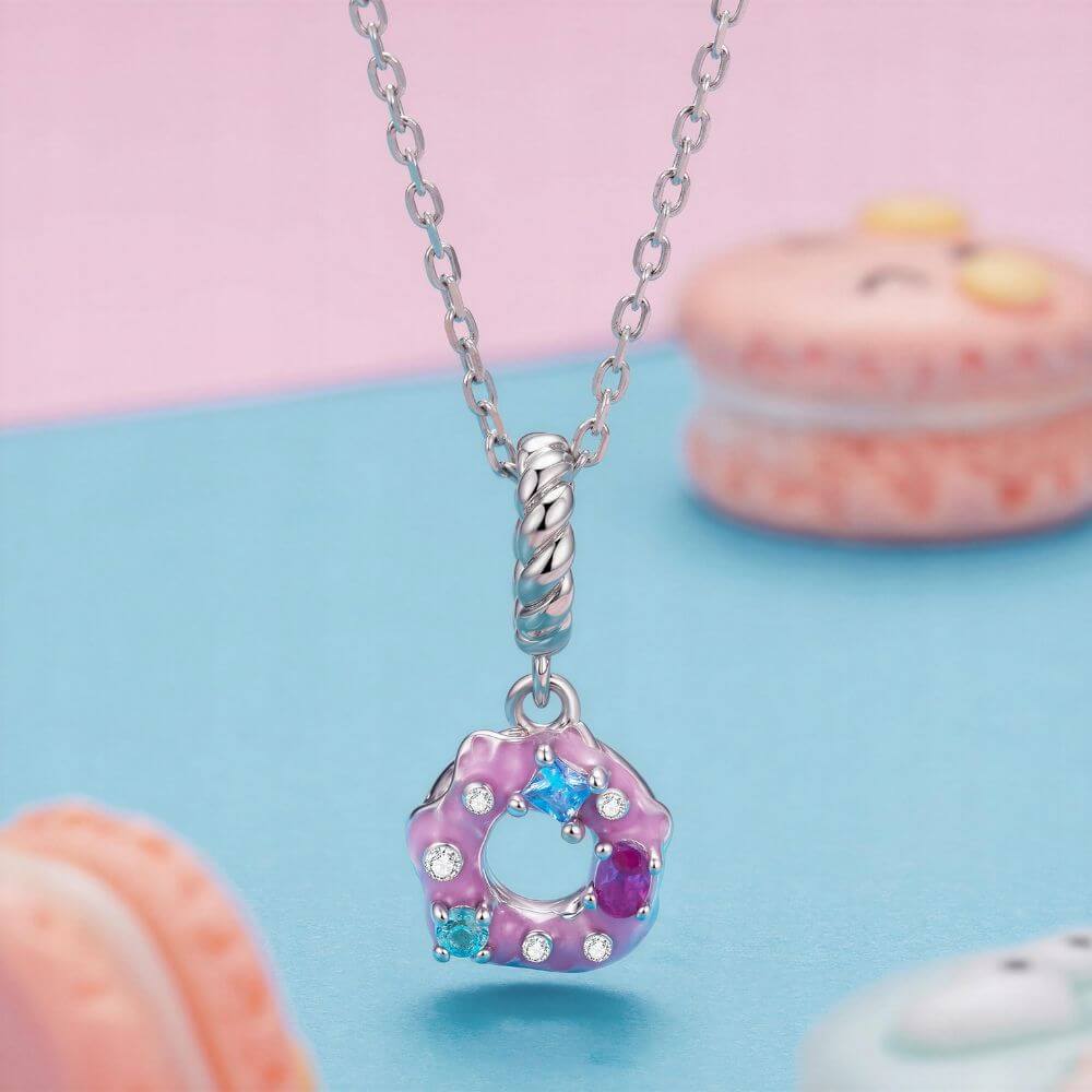 Sterling silver donut charm with pink frosting, colorful crystal sprinkles, and a twisted silver bail.