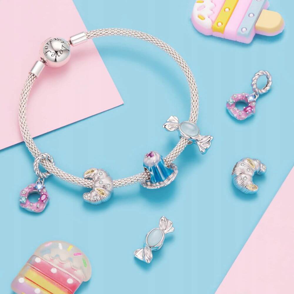 Sterling silver donut charm with pink frosting, colorful crystal sprinkles, and a twisted silver bail.