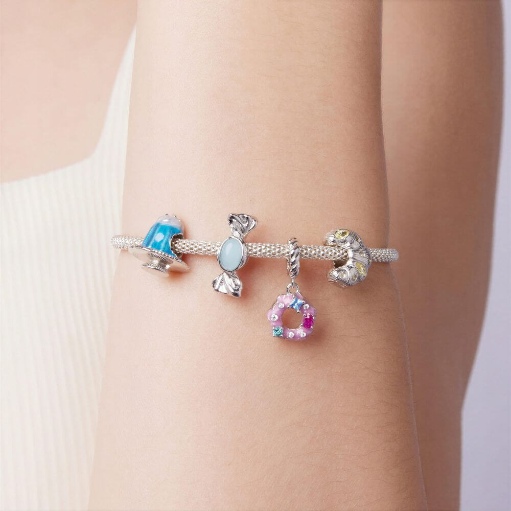 Sterling silver donut charm with pink frosting, colorful crystal sprinkles, and a twisted silver bail.