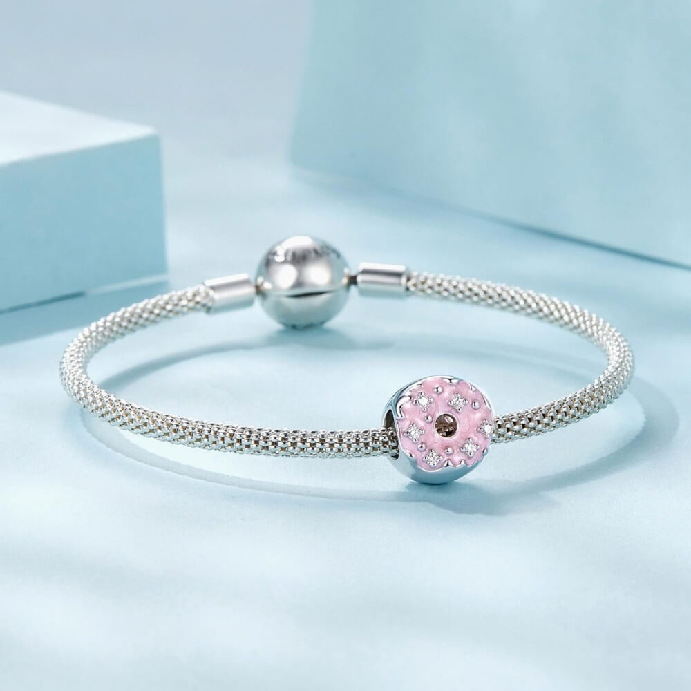 Sterling silver donut charm with pink enamel and crystal accents.