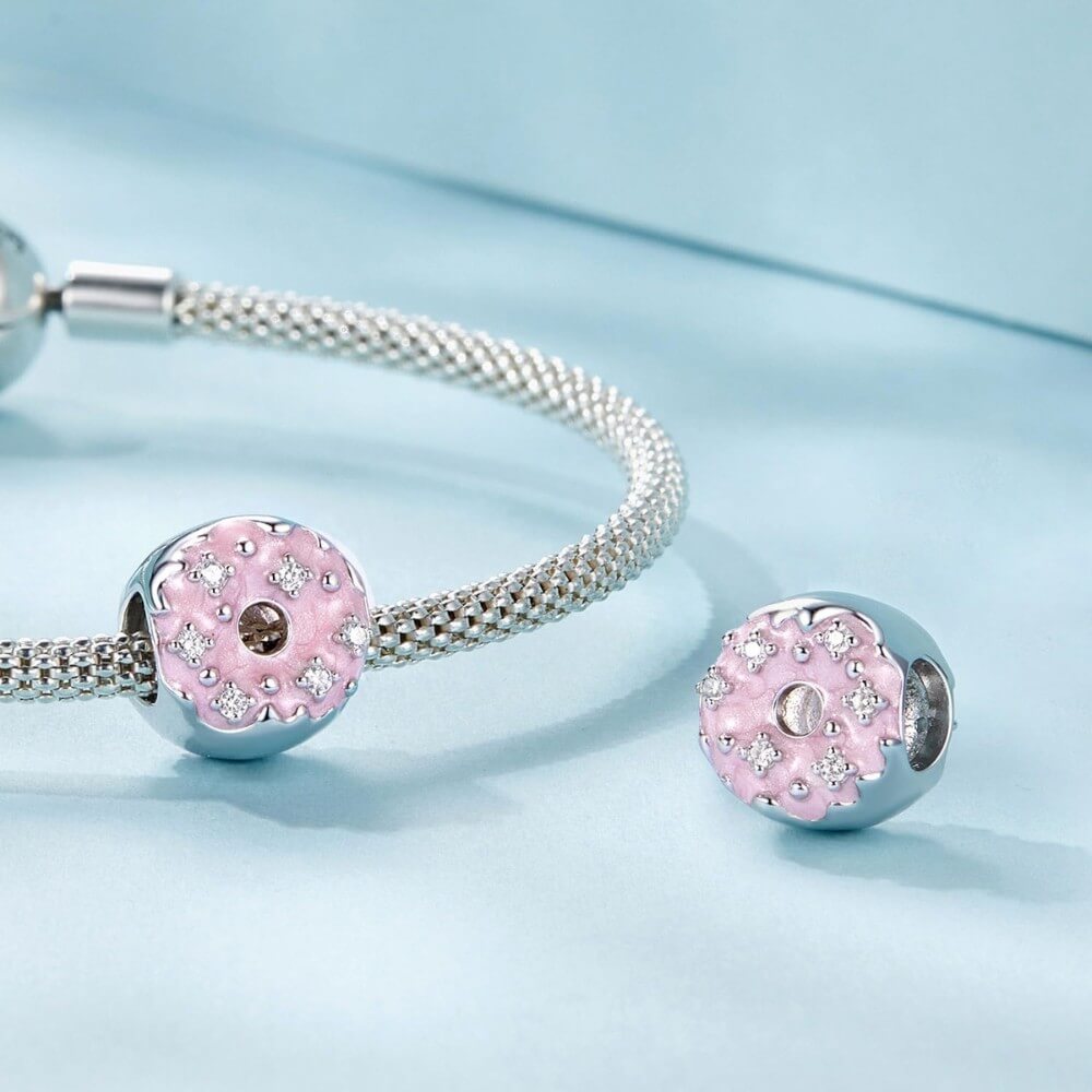 Sterling silver donut charm with pink enamel and crystal accents.