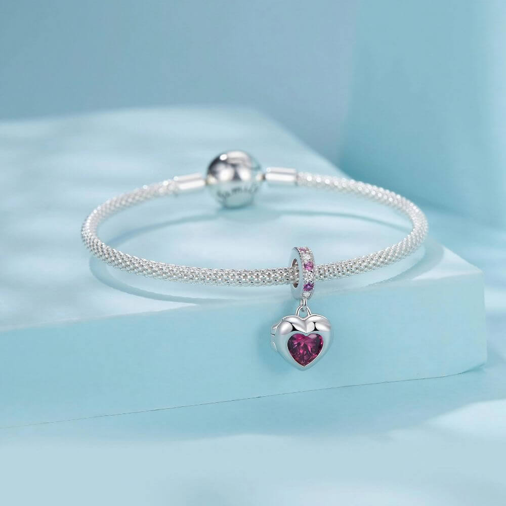 Sterling silver heart locket charm with deep pink crystal center and sparkling pink and clear stone details.