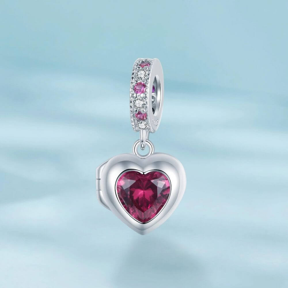 Sterling silver heart locket charm with deep pink crystal center and sparkling pink and clear stone details.
