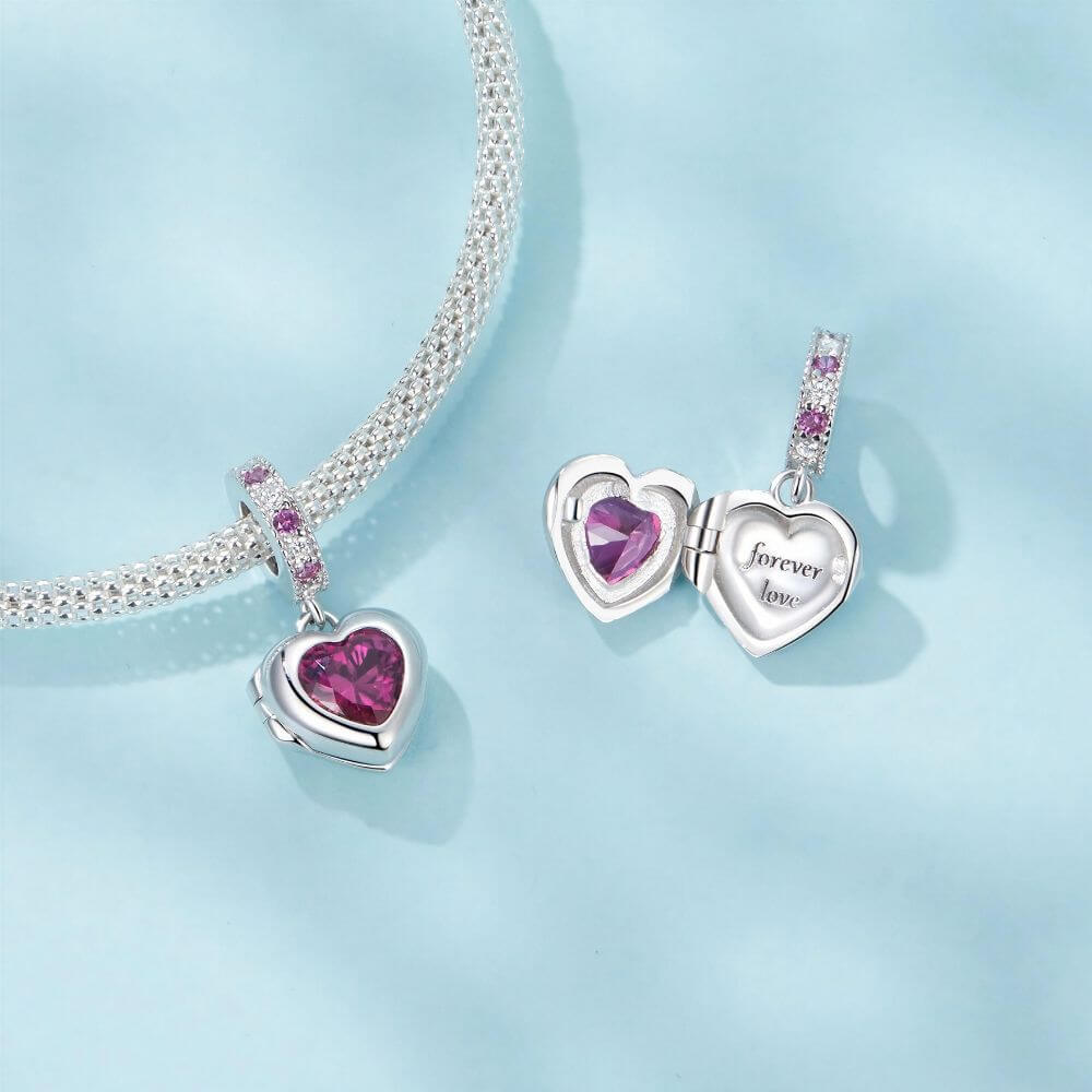 Sterling silver heart locket charm with deep pink crystal center and sparkling pink and clear stone details.