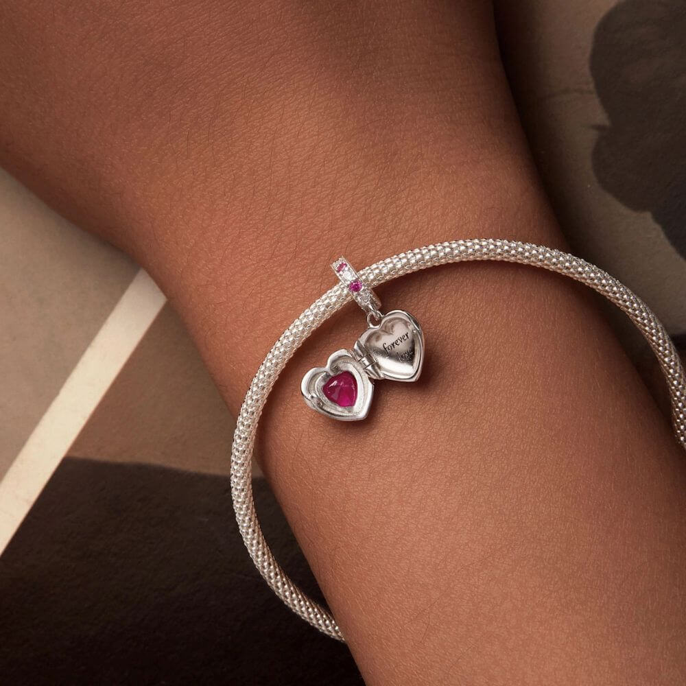 Sterling silver heart locket charm with deep pink crystal center and sparkling pink and clear stone details.