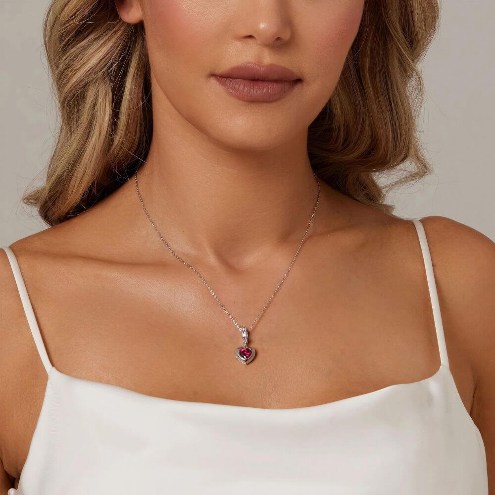Sterling silver heart locket charm with deep pink crystal center and sparkling pink and clear stone details.