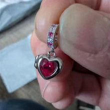 Sterling silver heart locket charm with deep pink crystal center and sparkling pink and clear stone details.