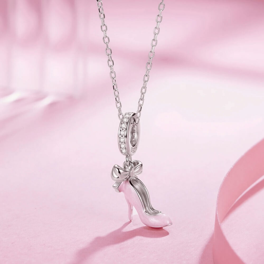 Sterling silver high heel charm with pink enamel and bow detail.