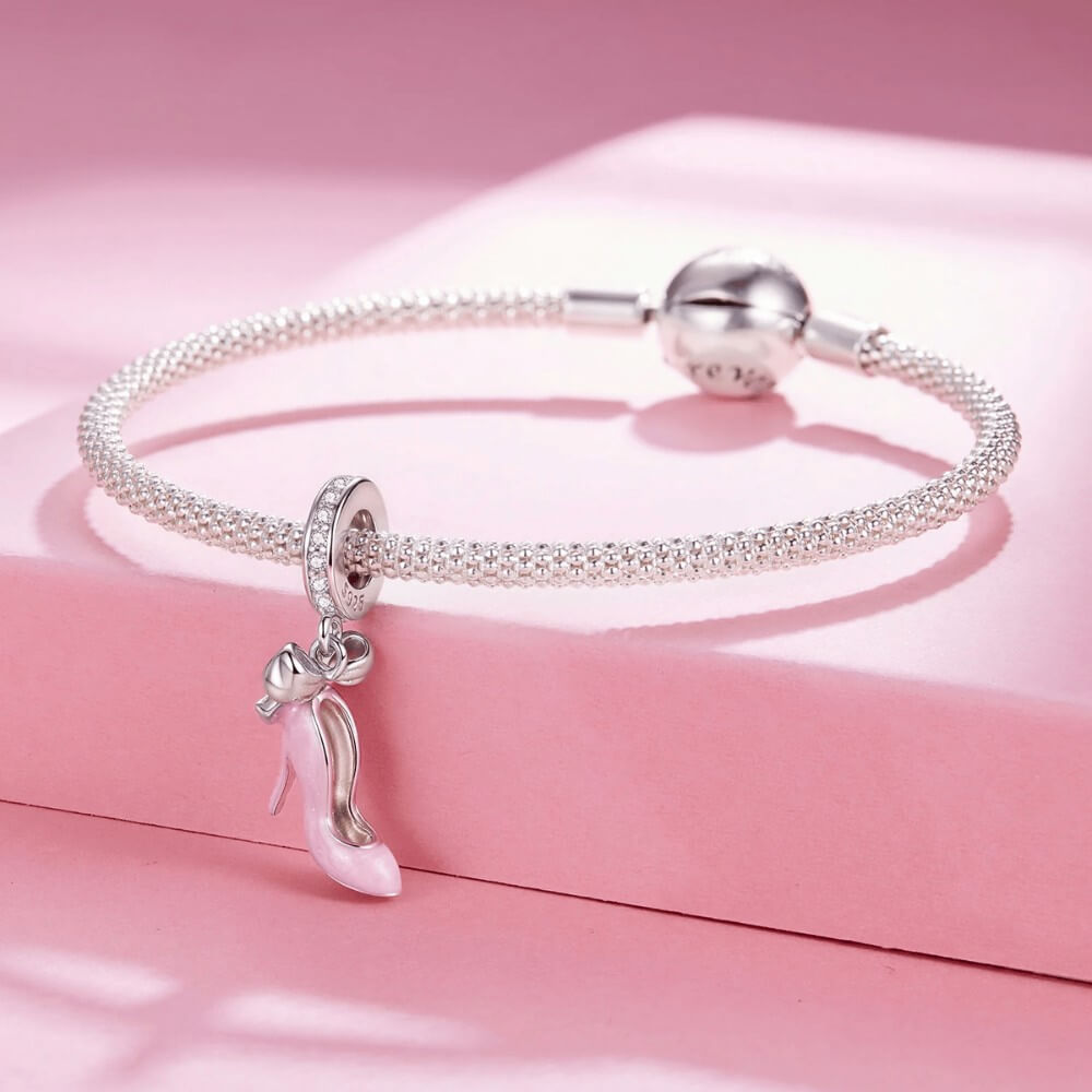 Sterling silver high heel charm with pink enamel and bow detail.