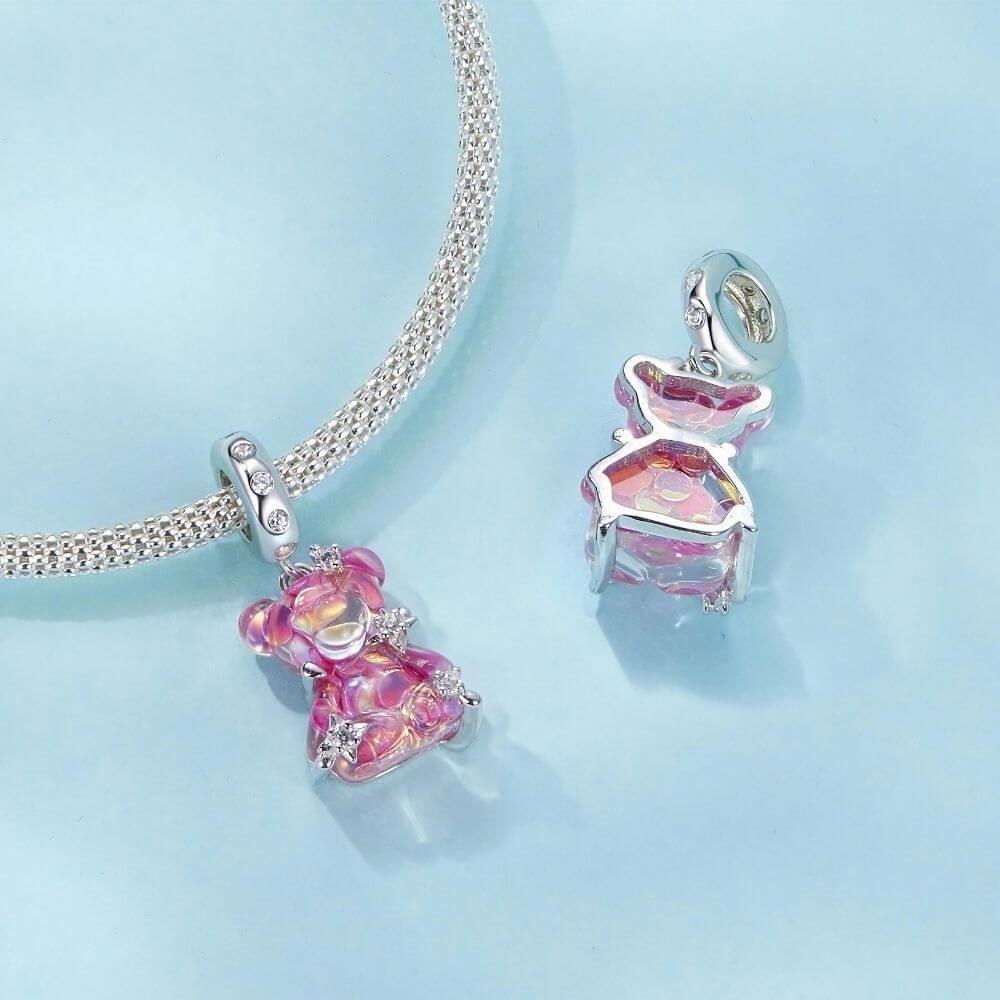 Sterling silver pink teddy bear charm with iridescent finish, sparkling stars, and clear crystal accents.