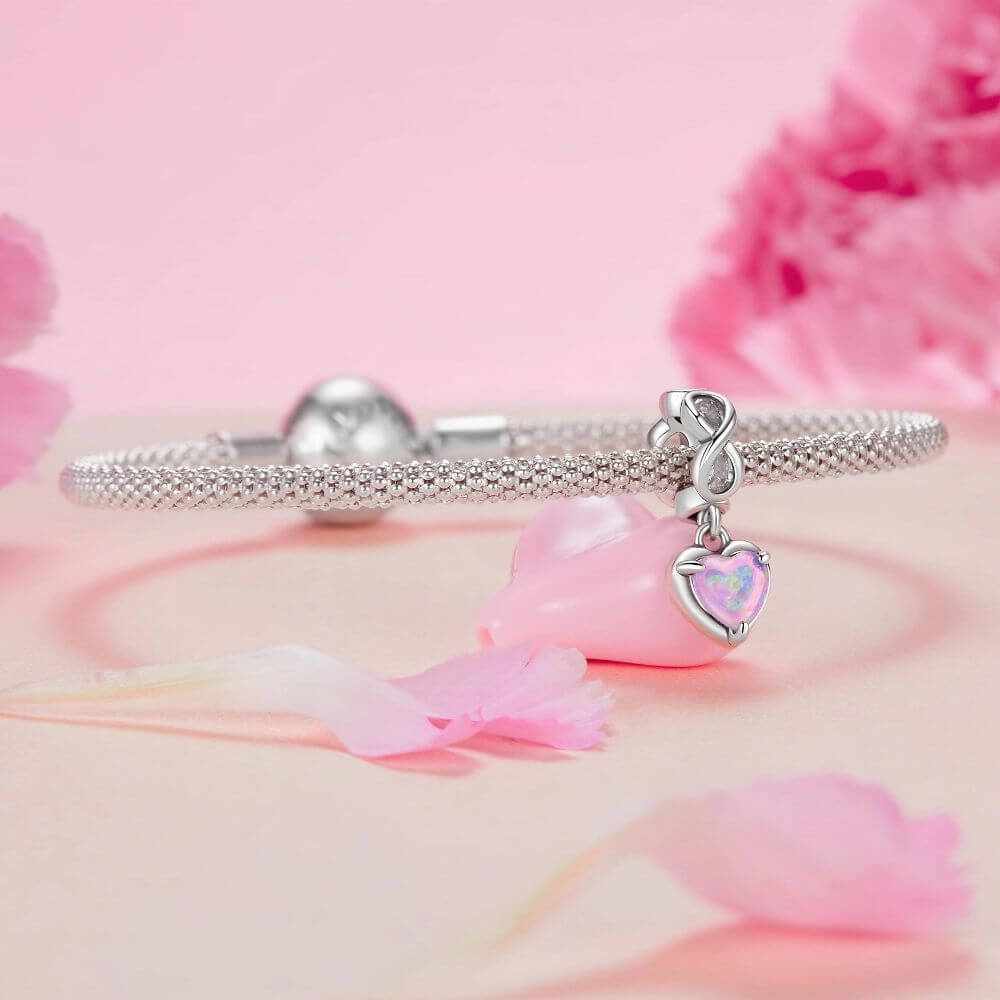 Sterling silver heart charm with pink opal center, infinity loop, and sparkling clear crystal details.