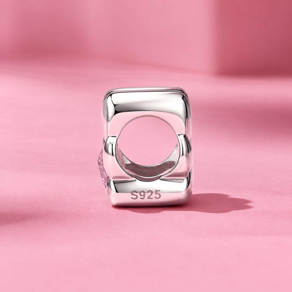 Sterling silver paw print charm with pink heart crystal center and polished pet-inspired details.