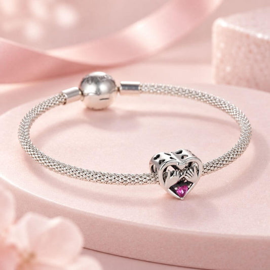 Sterling silver pinky promise charm with intertwined hands, pink heart crystal, and romantic heart frame.