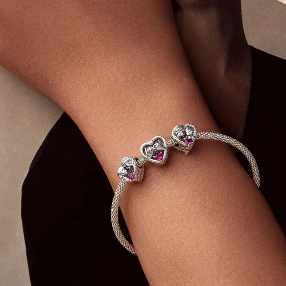 Sterling silver pinky promise charm with intertwined hands, pink heart crystal, and romantic heart frame.