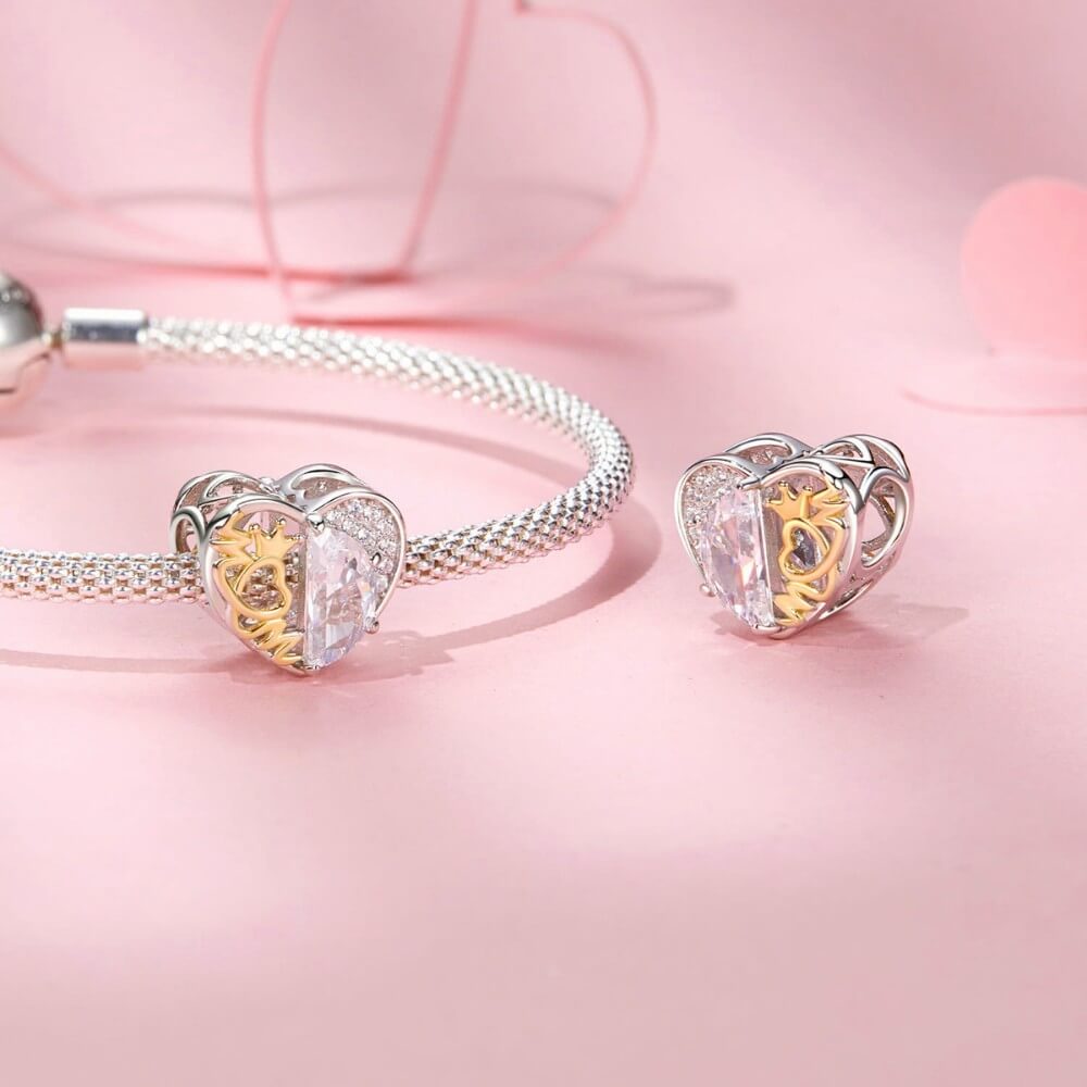 Sterling silver heart charm with golden crown detail and clear crystal.