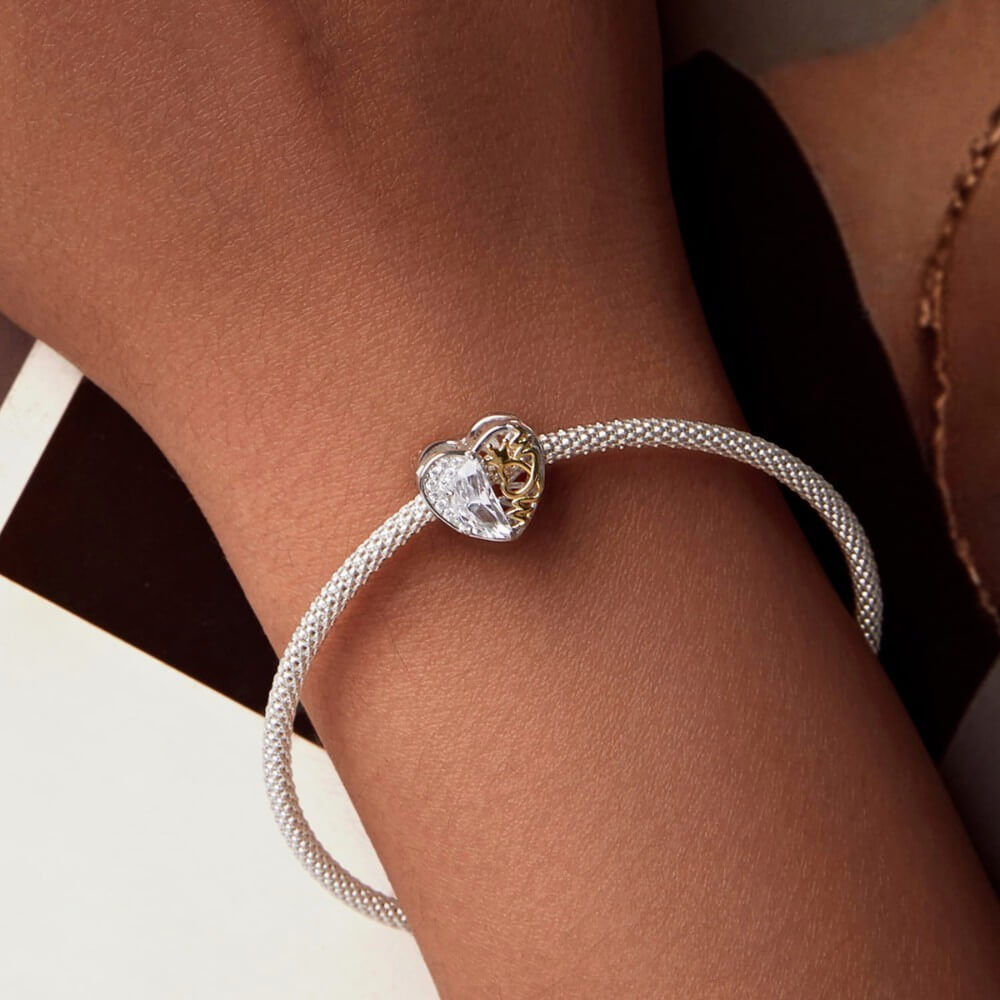 Sterling silver heart charm with golden crown detail and clear crystal.