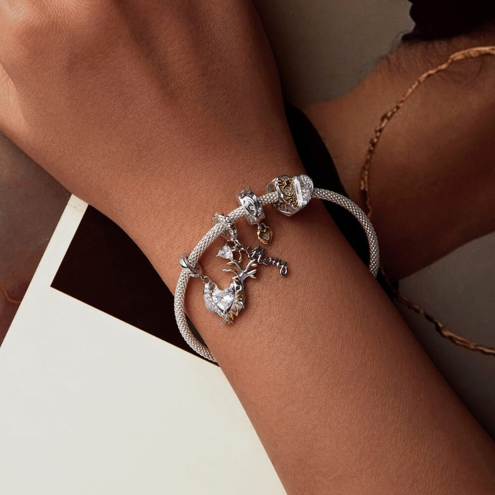 Sterling silver heart charm with golden crown detail and clear crystal.