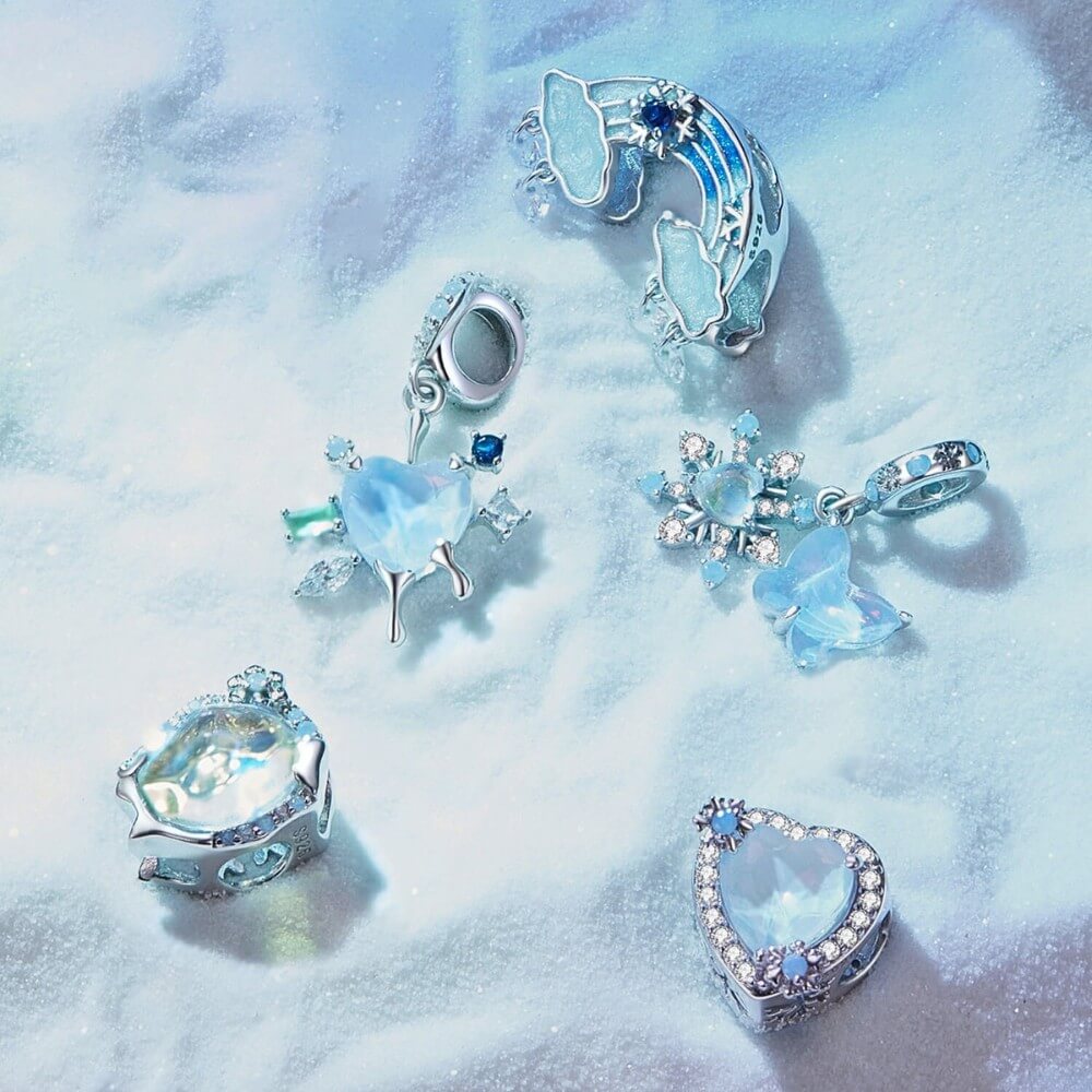 Sterling silver rainbow charm with clouds and dangling crystal drops.