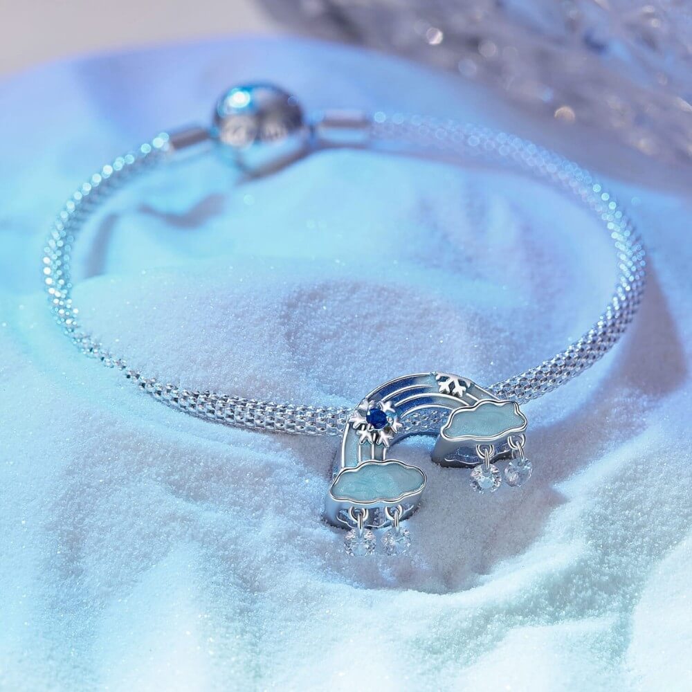 Sterling silver rainbow charm with clouds and dangling crystal drops.