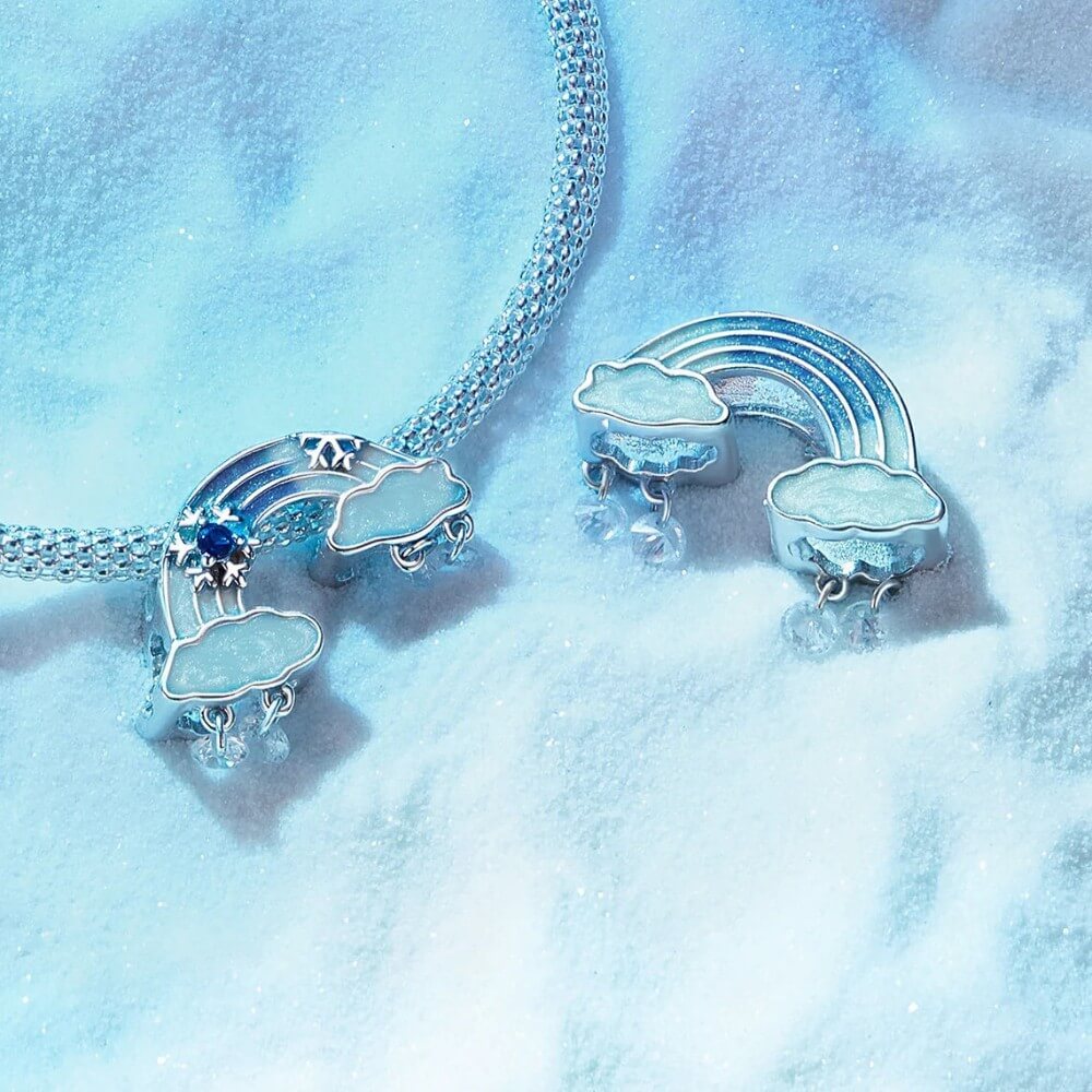 Sterling silver rainbow charm with clouds and dangling crystal drops.