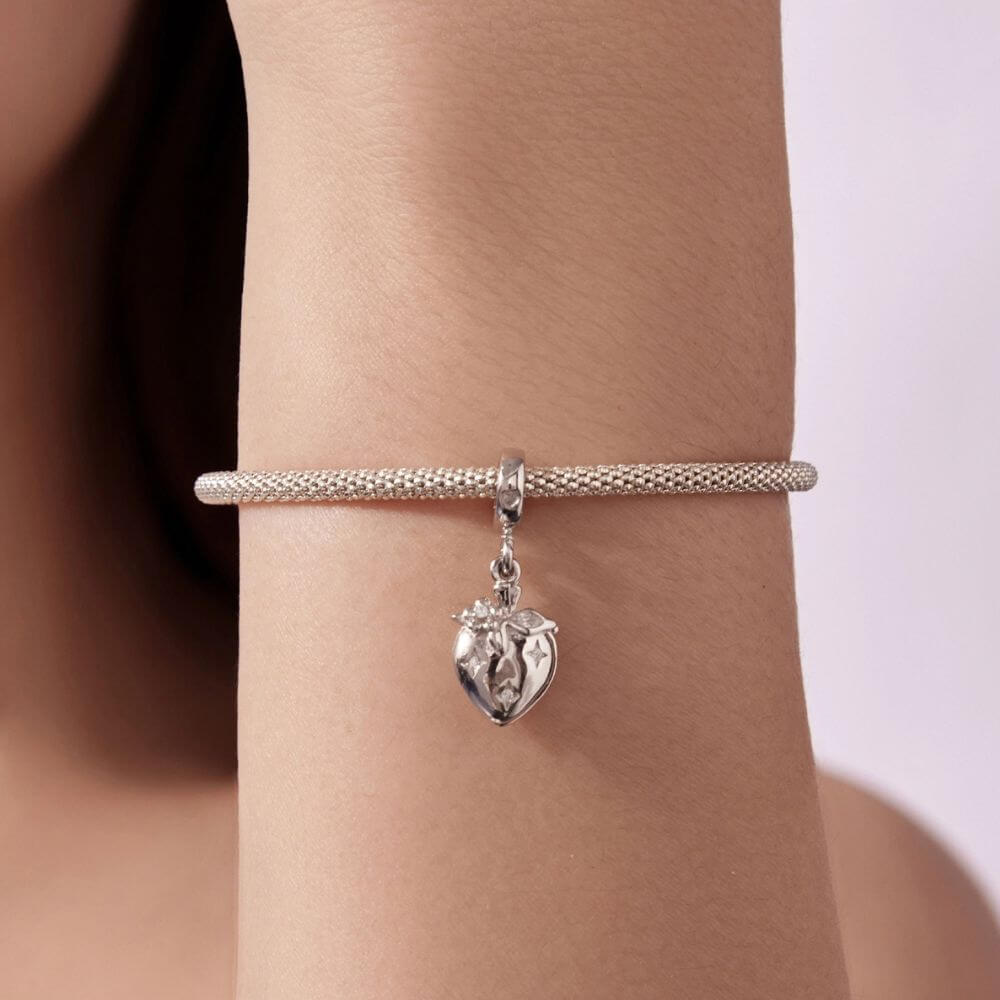 Sterling silver heart charm with red crystal center, floral details, stars, and a romantic double-heart design.