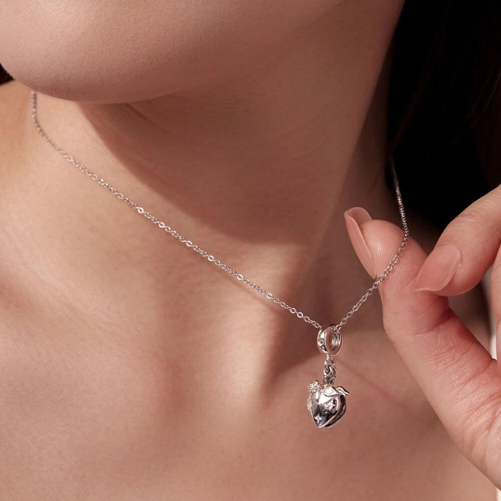 Sterling silver heart charm with red crystal center, floral details, stars, and a romantic double-heart design.