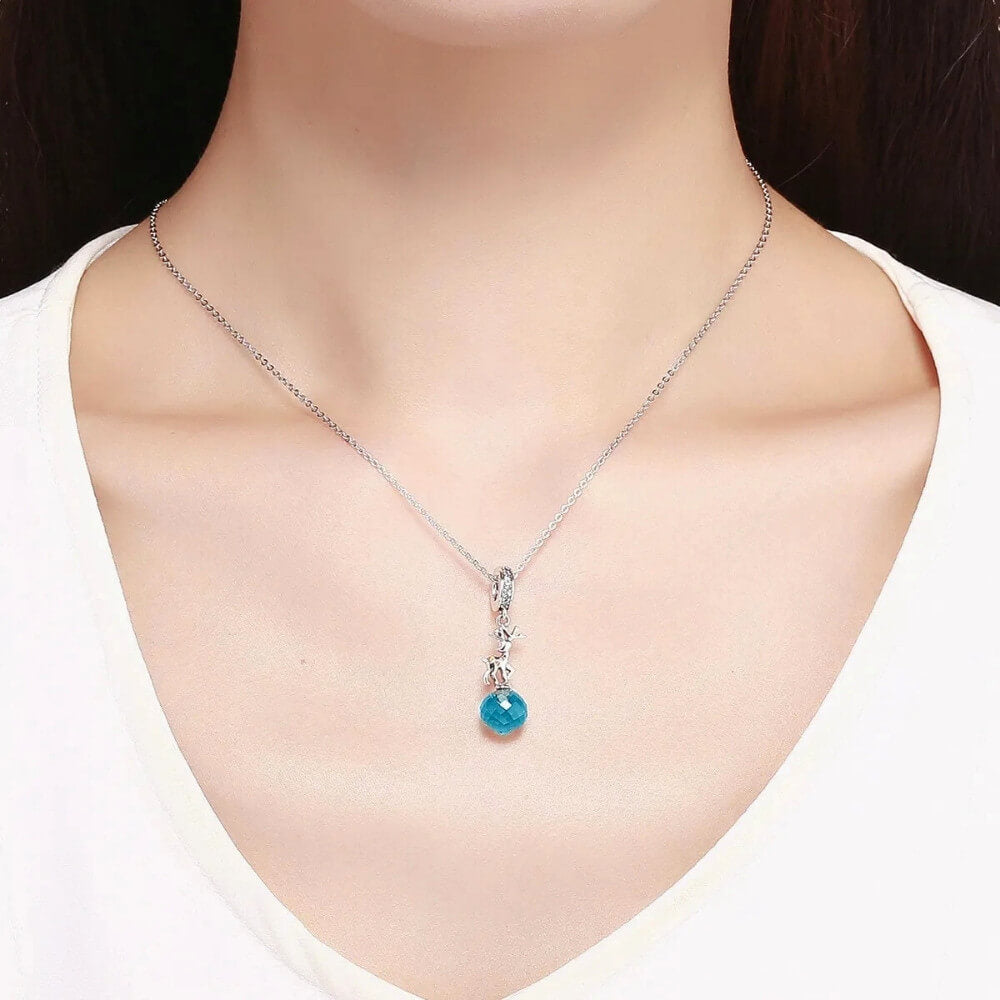 Sterling silver reindeer charm with orange gemstone spots and blue faceted crystal drop.