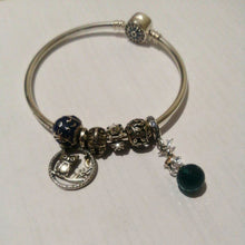 Sterling silver reindeer charm with orange gemstone spots and blue faceted crystal drop.