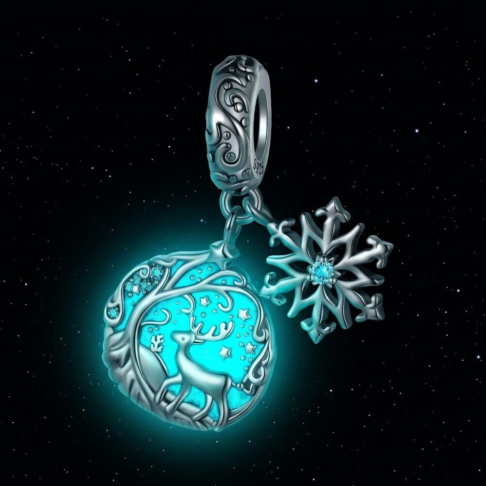Sterling silver reindeer charm with blue enamel heart, snowflake dangle, stars, and winter forest details - ORÉYA
