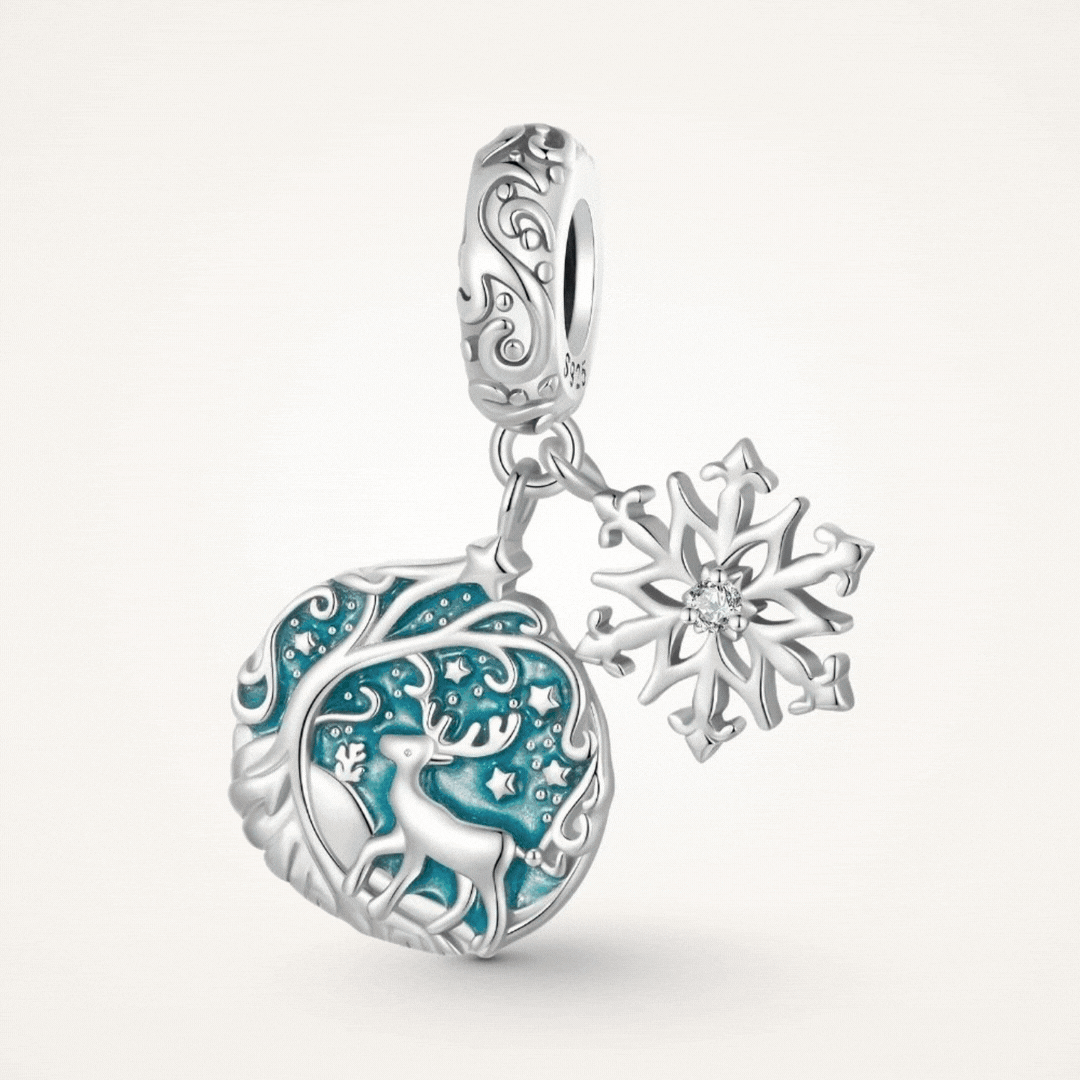 Sterling silver reindeer charm with blue enamel heart, snowflake dangle, stars, and winter forest details - ORÉYA
