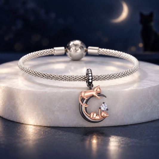 Rose gold cat moon charm with two playful cats, black crescent moon, and sparkling heart crystal detail.