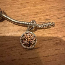 Sterling silver tree charm with rose gold branches, clear gemstones, and circular frame.