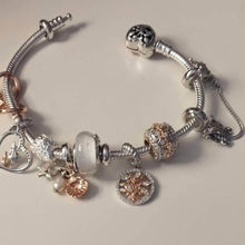 Sterling silver tree charm with rose gold branches, clear gemstones, and circular frame.