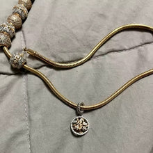 Sterling silver tree charm with rose gold branches, clear gemstones, and circular frame.
