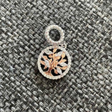 Sterling silver tree charm with rose gold branches, clear gemstones, and circular frame.