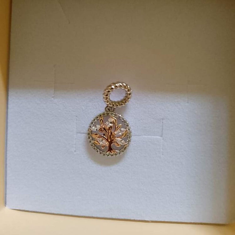 Sterling silver tree charm with rose gold branches, clear gemstones, and circular frame.