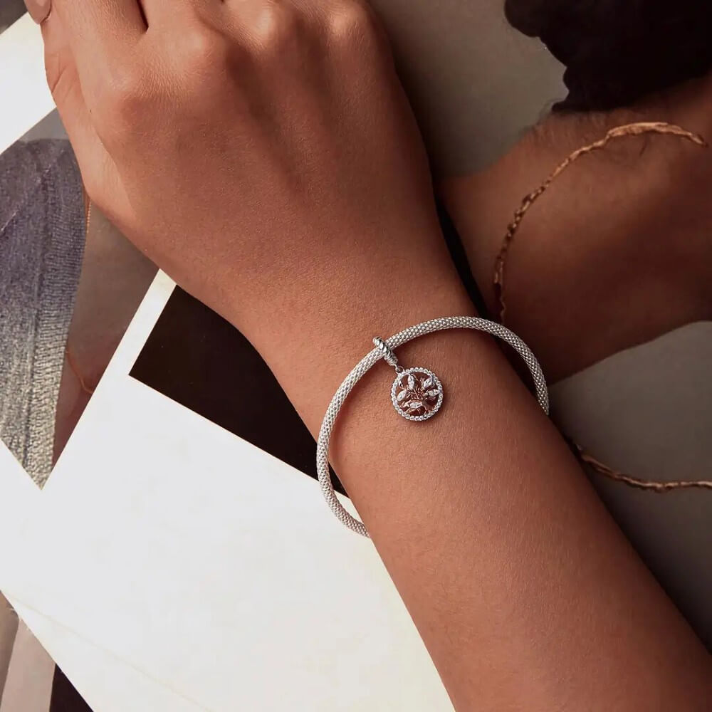 Sterling silver tree charm with rose gold branches, clear gemstones, and circular frame.