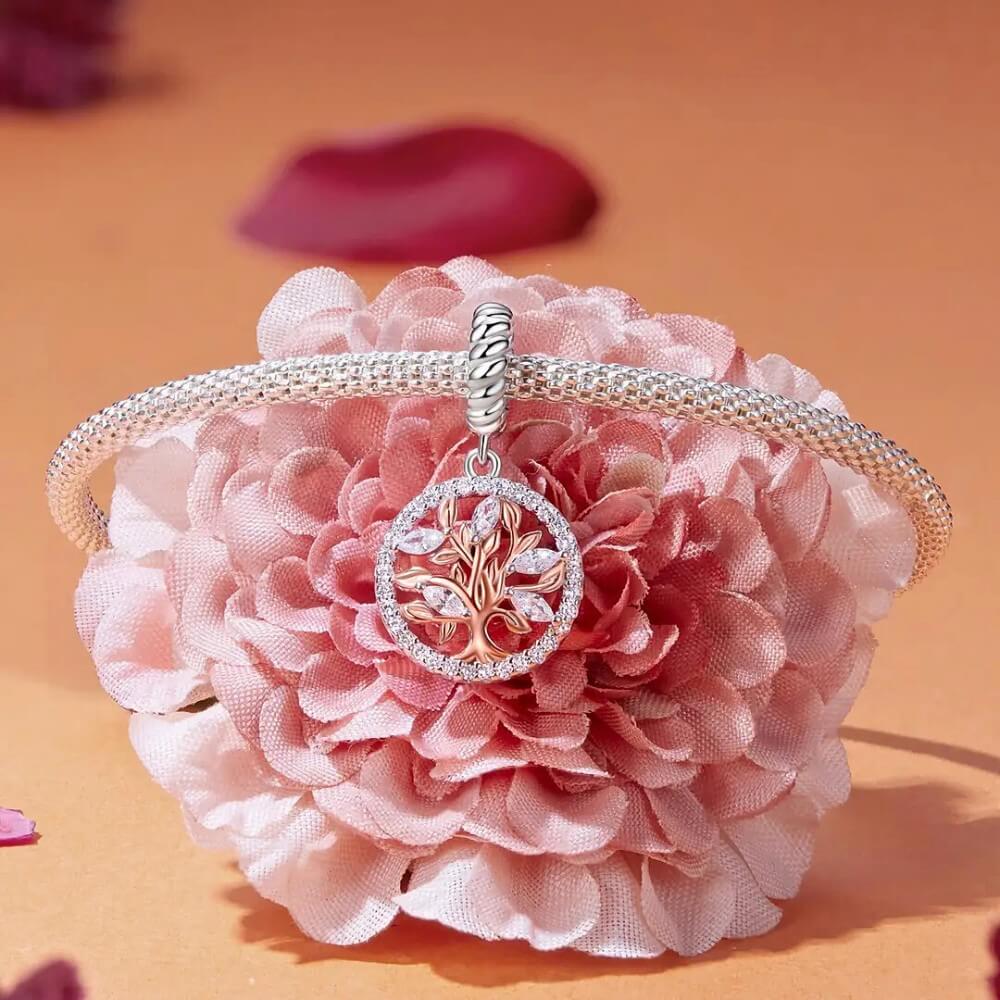 Sterling silver tree charm with rose gold branches, clear gemstones, and circular frame.