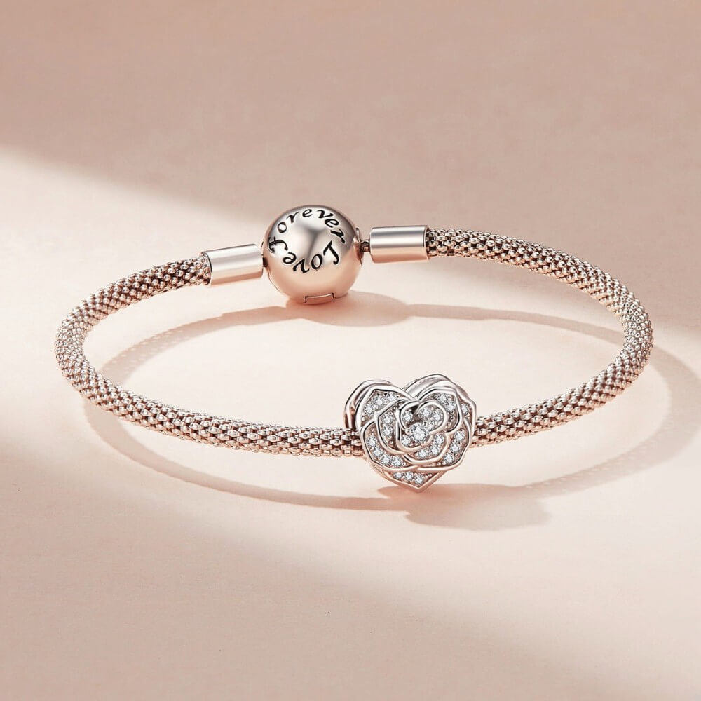 Silver bracelet with heart-shaped charm on a beige background
