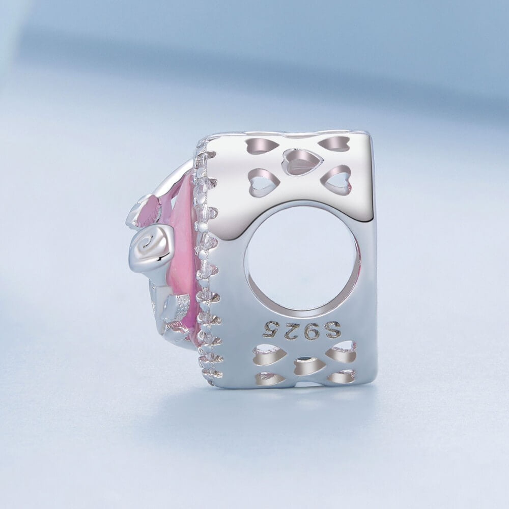 Sterling silver rose heart charm with pink opal center and crystal border.